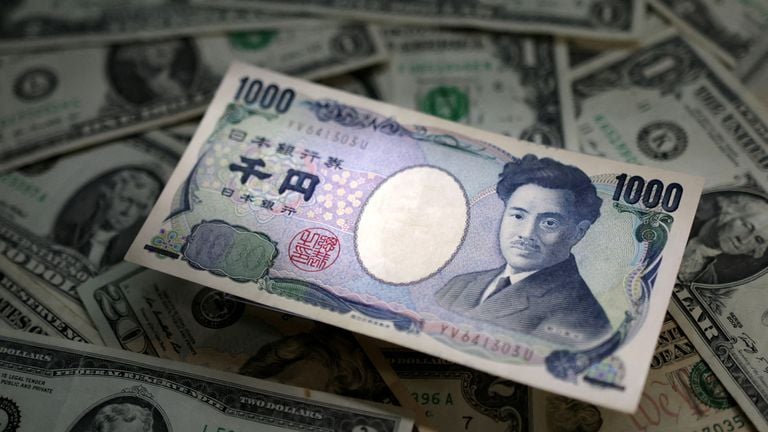 Reuters image of a Japanese yen banknote over U.S. dollar notes.